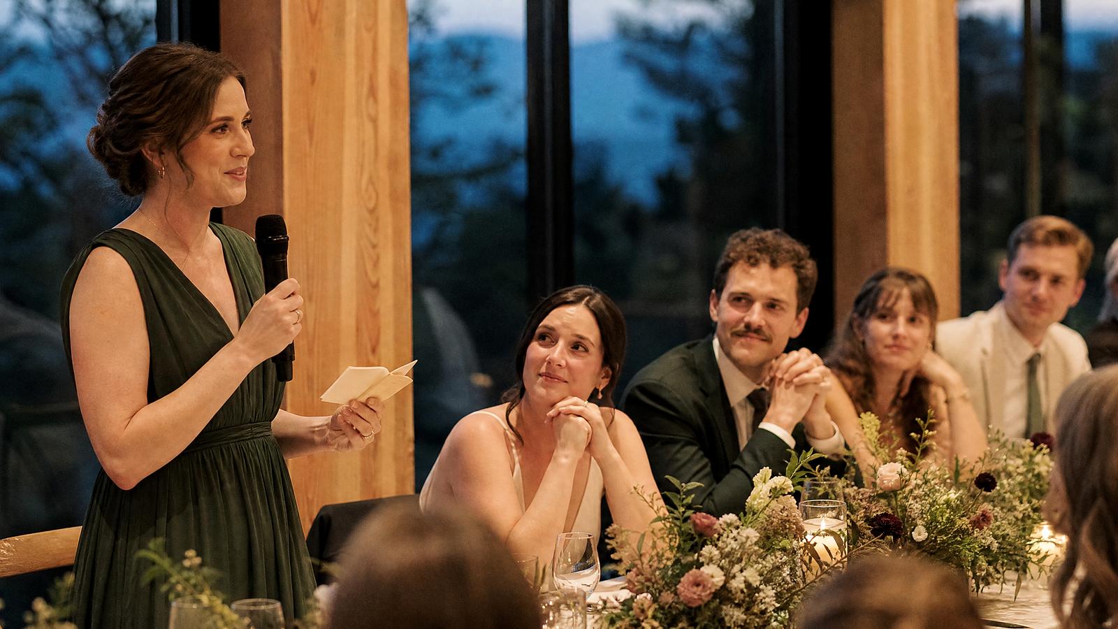 A wedding-party speaker holding cue cards and speaking to the newlyweds